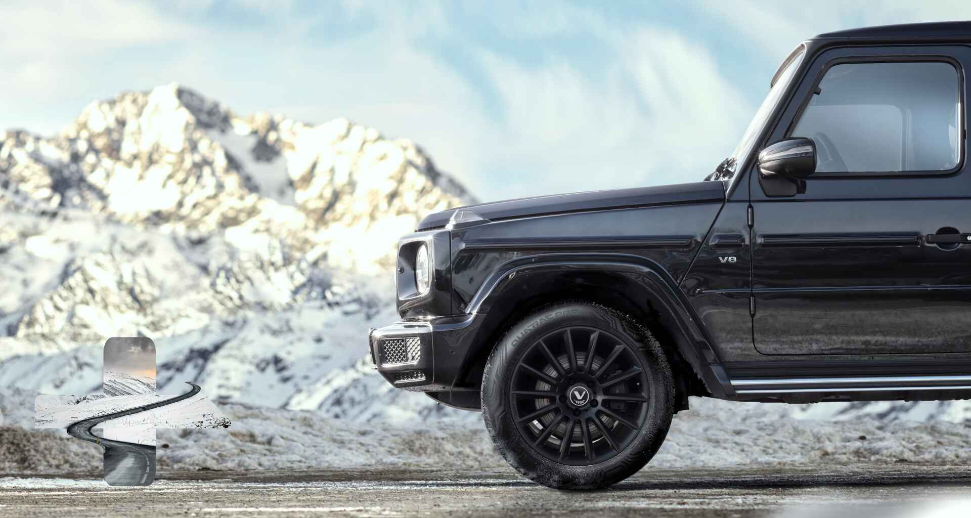 Seitenansicht eines Autos mit verschneiten Bergen im Hintergrund und sichtbarem Reifen.